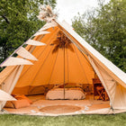 Glowing orange Bell Tent Plus with interior details in a natural setting