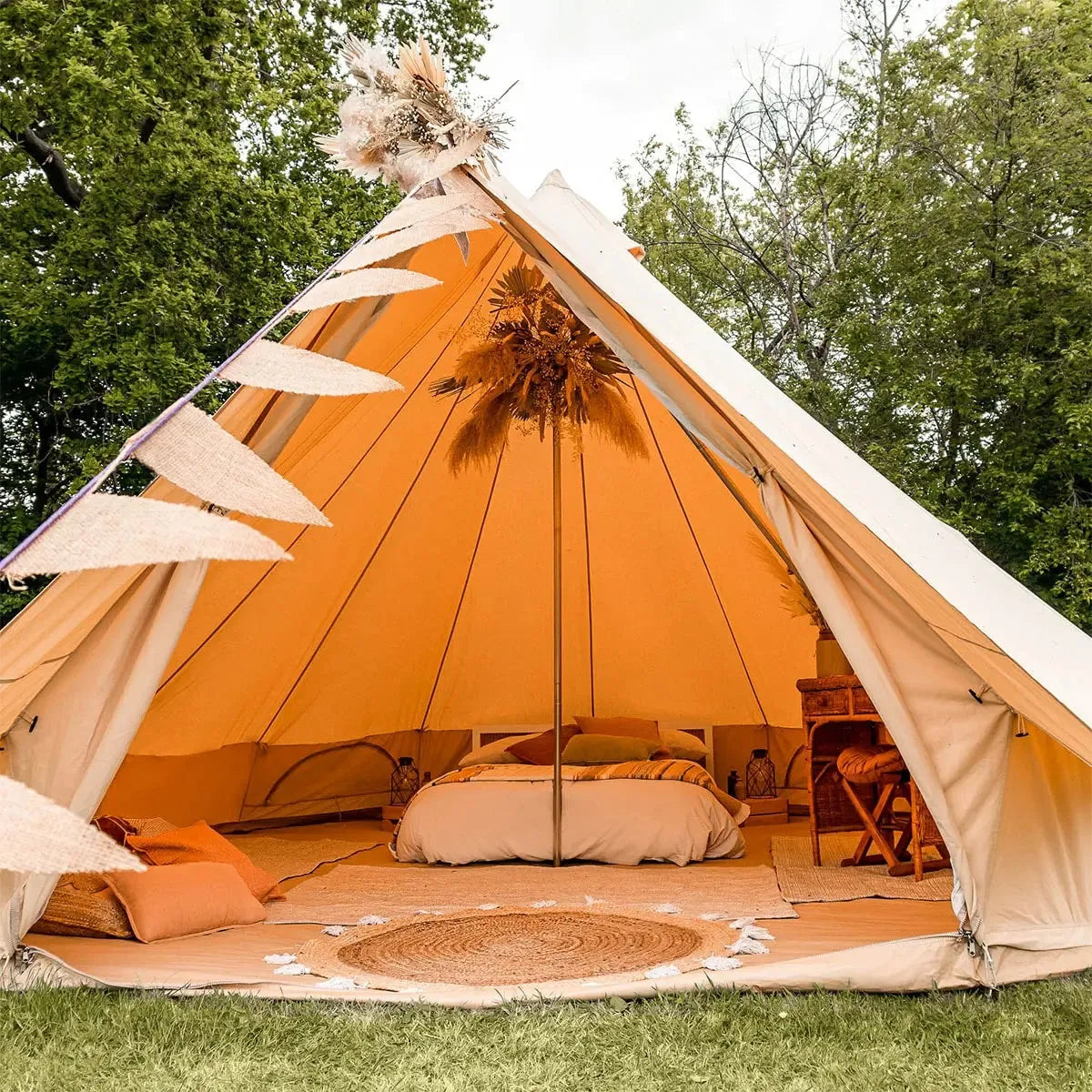 Glowing orange Bell Tent Plus with interior details in a natural setting
