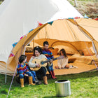 a woman and her family enjoying camping with a guitar and fire outside a 6m star bell tent