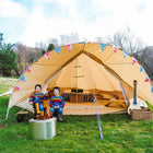 two boys sitting outside a boutique camping canvas tent with a guitar and double bed in the tent