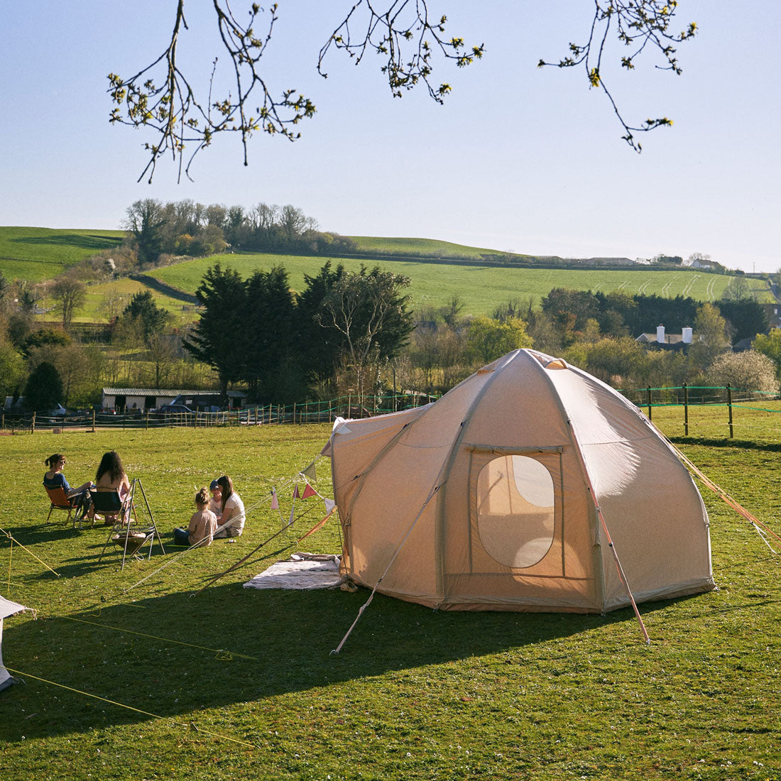 nova air dome glamping tent in a green field with children playing