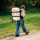 boutique camping bell tent back pack carried by a girl on a green pathway