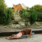 a lady doing yoga in the foreground with some cobbled steps and plants in the mid ground leading up to the tucana tent in the background