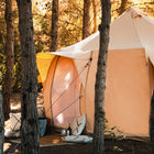 boutique camping luna bell tent close up in a forest with pillows and accessories