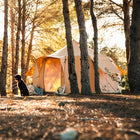 side view of boutique camping's luna bell tent with a dog and sunset orange glow