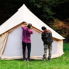 two people setting up the 5m bell tent pro in a forest setting
