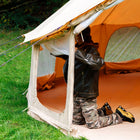 person rolling up mesh side windows of boutique camping's 5m Bell Tent Pro tent