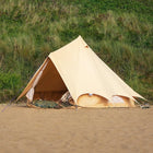 bell tent plus glamping tent set up on a sandy beach with grass in the background