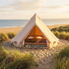 boutique camping bell tent plus 3m glamping tent forward facing with doors open and bedding inside on a beach at sunset 