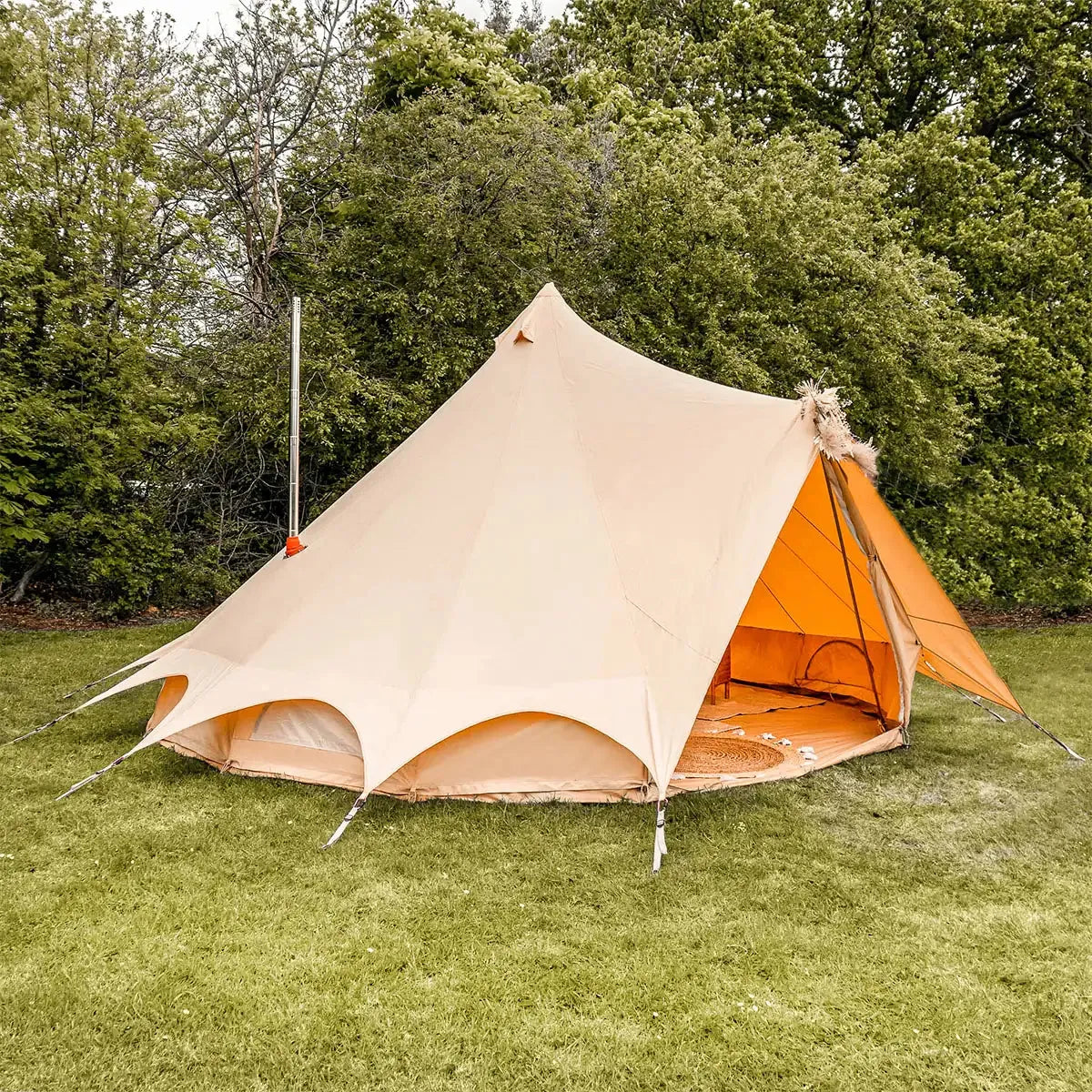 boutique camping bell tent plus fire retardant with stove flue side view in grassy field