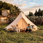Bell tent plus glamping tent exterior setup in tropical field