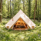 boutique camping fire retardant glamping tent in a forest with double bed and stove