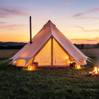 bell tent plus fire retardant glamping tent at sunset in a field with stove and golden lighting 