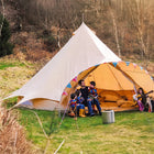 boutique camping star bell tent pitched on grass with bunting and gutiar and kids playing in tent with dad