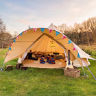 boutique camping star bell tent pitched on grass with bunting and gutiar and kids playing in tent with dad