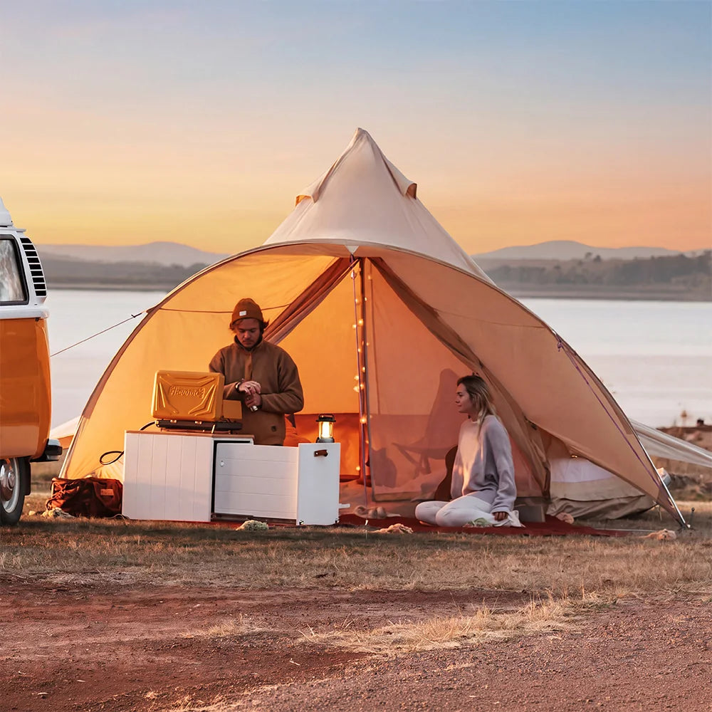 boutique camping star bell tent with couple at golden hour hanging outside of tent about to cook outdoor dinner