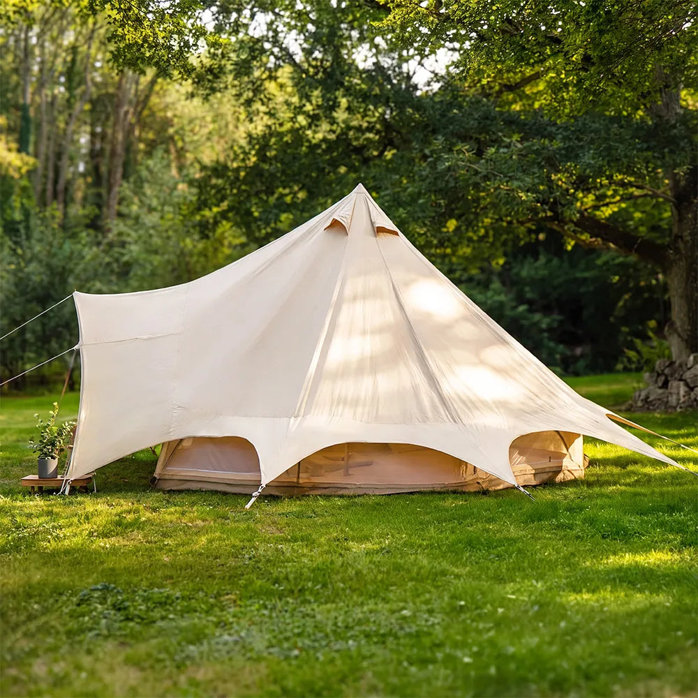 boutique camping star bell tent pitched on grass with integrated canopy