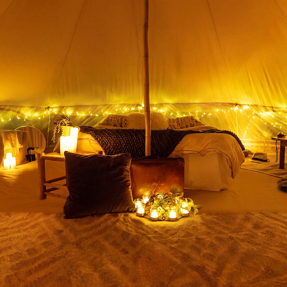 boutique camping bell tent interior with bamboo pole and cosy soft furnishings