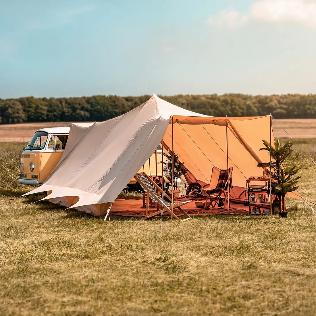 Camper van with a double door tucana tent and glamping furniture in a field