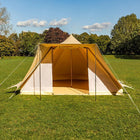 boutique camping tucana tent with open front door set up on a grassy field with trees in the background 