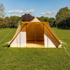 boutique camping tucana tent with open front door set up on a grassy field with trees in the background 