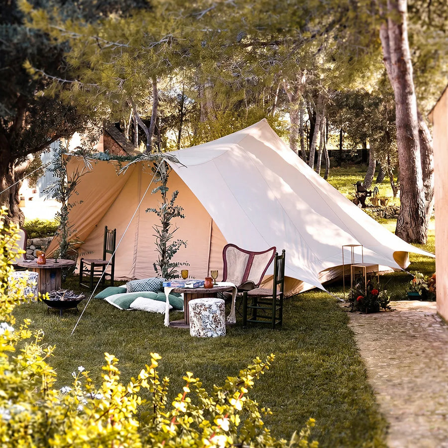 boutique camping large tucana bell tent set up in grassy area with outdoor furniture and decorations 