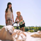 two children happily pumping up the nova air dome tent with a sunny sky in the background 