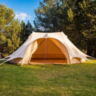 A boutique camping star emperor bell tent pitched on a grassy lawn with trees and blue sky in the background.
