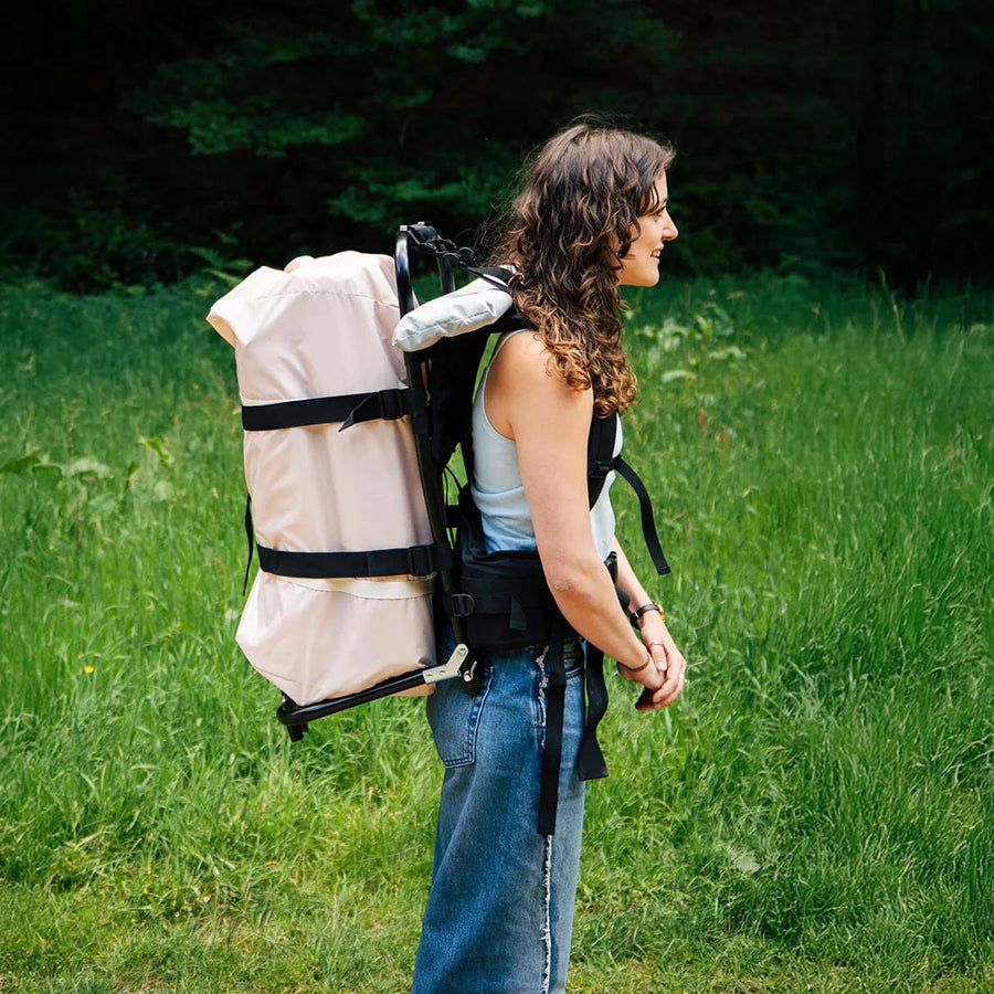 girl carrying a boutique camping bell tent and backpack carrier 