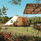 boutique camping's tucana tent featuring a rattan canopy and greenery around the edges 