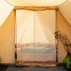 view of the netted door of the tucana glamping tent with visibility of the double bed inside the tent