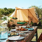 a table of sicilian food in the foreground with the tucana tent slightly out of focus in the background 