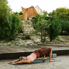 a lady doing yoga in the foreground with some cobbled steps and plants in the mid ground leading up to the tucana tent in the background 