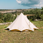 back view of the tucana tent situated on grass with trees and a blue sky 