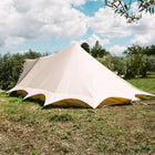 back view of the tucana tent situated on grass with trees and a blue sky 