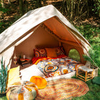 Relaxing scene inside the Vela Air Tent with pillows and vibrant decor – Ideal luxury glamping tent from Boutique Camping
