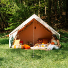 Spacious Vela Air Tent with bright orange cushions and natural wood accents – Perfect glamping setup from Boutique Camping
