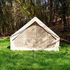 Rear angle of the Vela Air Tent pitched on grassy ground, framed by soft woodland light.