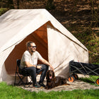 happy man and dog sitting outside the boutique camping vela air tent in the sunshine