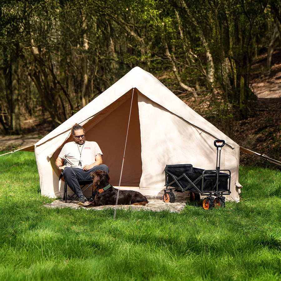  Vela Air Tent fully set up on a bright grassy field, featuring its wide doorway and durable beige fabric.