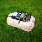 Compactly packed Vela Air Tent bag and components placed on the grass.